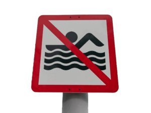 Verbotsschild Schwimmen Ein Verbotsschild mit einem Symbol, das das Schwimmen in einem Gewässer untersagt.